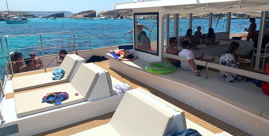 Malta: Blue Lagoon Evening Catamaran Cruise - On board vibe: adults-only, music, bar service, and real downtime
